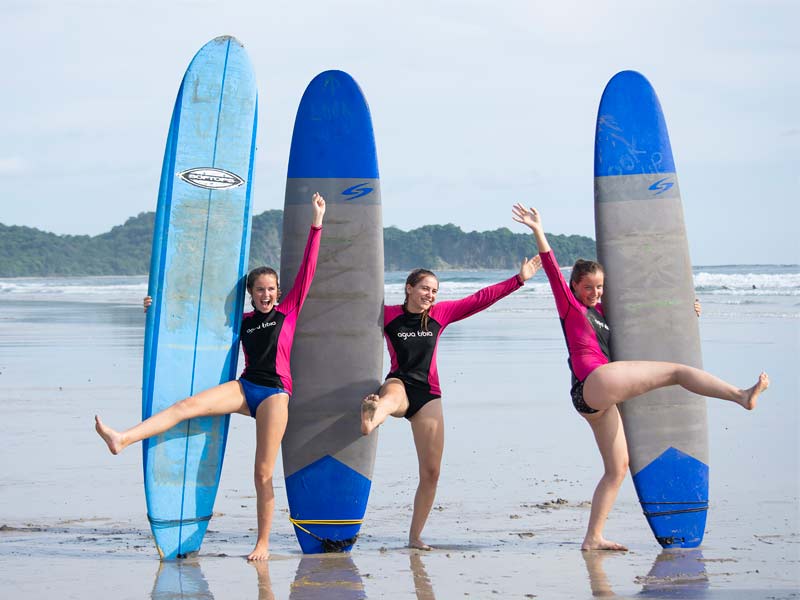 Trois filles au Costa Rica avec des planches de surf